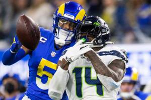 Los Angeles Rams cornerback Jalen Ramsey (5) stops a pass intended to Seattle Seahawks wide receiver DK Metcalf (14) during an NFL football game Tuesday, Dec. 21, 2021, in Inglewood, Calif. (AP Photo/Kyusung Gong)
