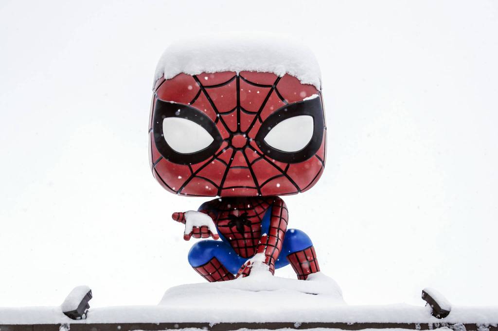 The friendly neighborhood web-slinger is blanketed in snow Sunday afternoon in Everett. (Kevin Clark / The Herald)