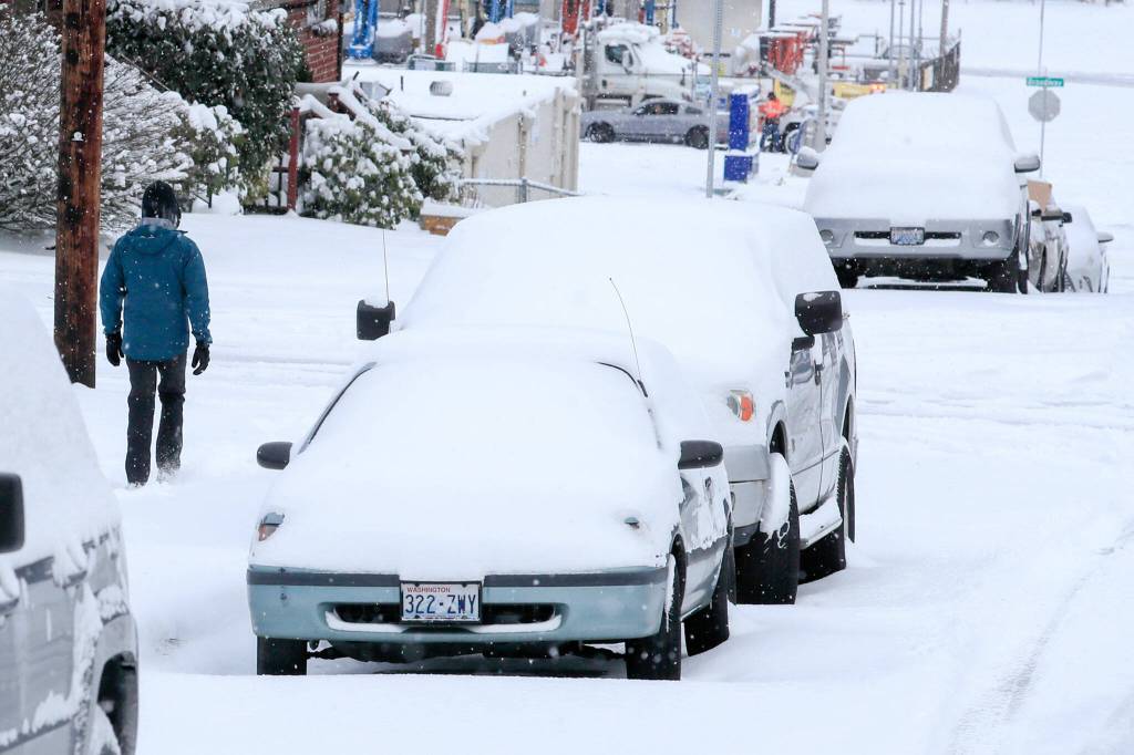 Cars and streets are blanketed in snow Sunday afternoon in Everett. (Kevin Clark / The Herald)