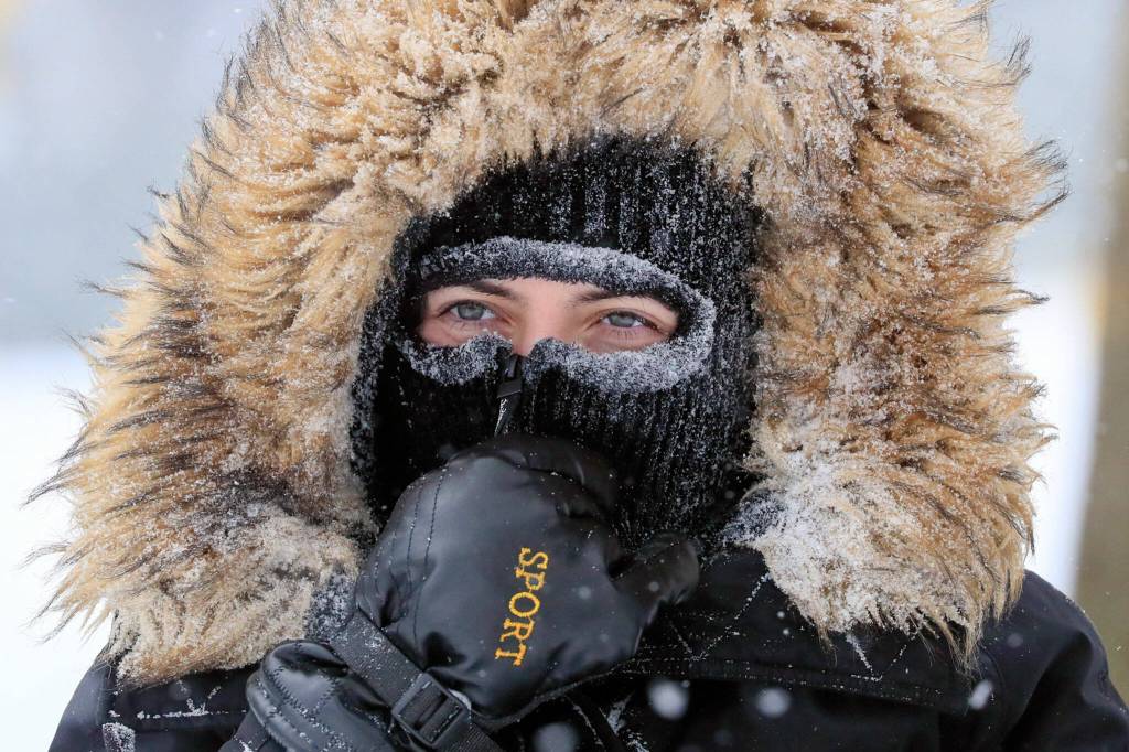 Mari Cortes is bundled up against the wind and snow at Forest Park on Sunday afternoon in Everett. (Kevin Clark / The Herald)