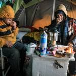 Brothers Jeff and Richard Williams layer up against the cold in their shared tent Wednesday afternoon in Arlington. (Kevin Clark / The Herald)