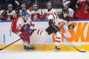 Canada's Olen Zellweger (3) is checked by Czech Republic's Michal Hradek (22) during third-period IIHF world junior hockey championship game action in Edmonton, Alberta, Sunday, Dec. 26, 2021. (Jason Franson/The Canadian Press via AP)