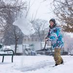 Justin Kennedy of Onslaught Crew, an action sports organization, clears the sidewalk from snow on Wednesday, Dec. 29, 2021 in the area where OC will have a ski and snowboard exhibition during the Potato Drop on New Year's Eve in Boise, Idaho. The National Weather Service is forecasting very cold temperatures in the Treasure Valley from Friday night through Sunday. (Sarah A. Miller /Idaho Statesman via AP)