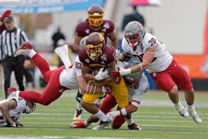 Central Michigan wide receiver JaCorey Sullivan (11) is stopped by Washington State defensive lineman Christian Mejia (93), edge rusher Quinn Roff (20) and defensive back Tyrone Hill Jr. (1) during the first half of the Sun Bowl NCAA college football game in El Paso, Texas, Friday, Dec. 31, 2021. (AP Photo/Andres Leighton)