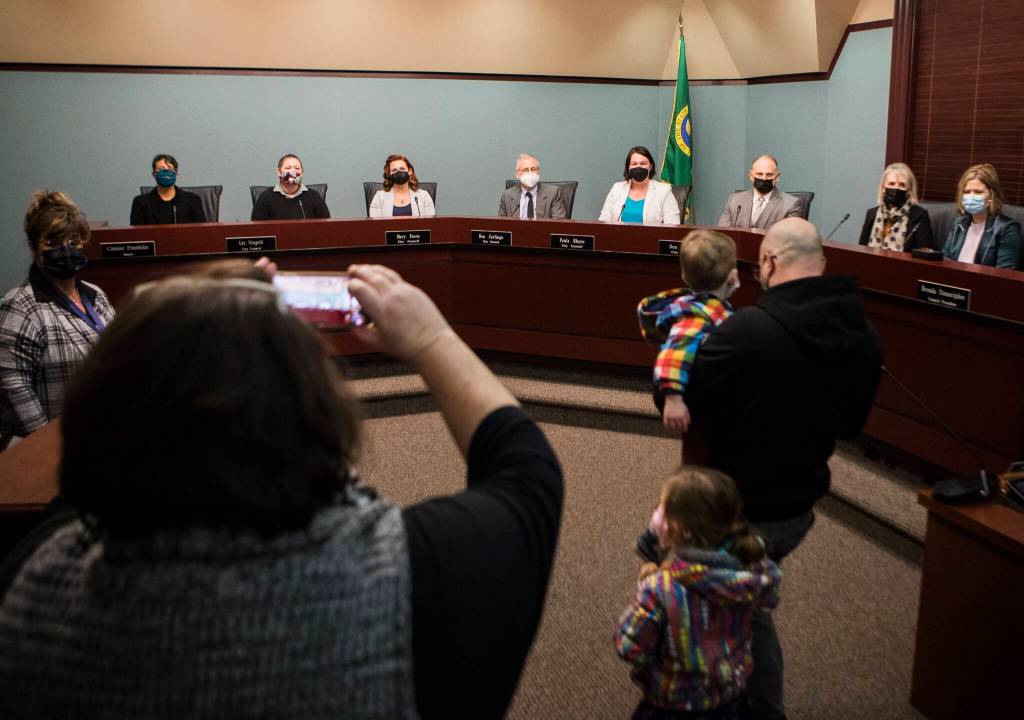 Family and friends of Everett City Council members take photos after the special meeting Monday in Everett. (Olivia Vanni / The Herald)