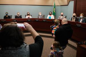 Family and friends of Everett council members take photos after the special meeting on Monday, Jan. 3, 2022 in Everett, Wa. (Olivia Vanni / The Herald)