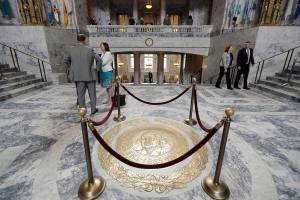 FILE - This April 22, 2019 file photo shows the Washington state seal protected by ropes in the rotunda of the Legislative Building at the Capitol in Olympia, Wash. The 60-day legislative session in Washington state begins Monday, Jan. 13, 2020, with lawmakers set to make adjustments to the state budget as well as tackle several policy issues, including how to address homelessness in the state. (AP Photo/Ted S. Warren, File)
