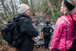 Catholic Community Services case manager Rhonda Polly (left) chats with COET social worker Kelli Roark (right) as they check on known encampments during the annual Point in Time count Jan. 23, 2019, in Everett. (Olivia Vanni / Herald file)