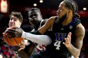 Washington guard PJ Fuller (4) and Arizona center Oumar Ballo (11) fight for a possession of a rebound during the first half of an NCAA college basketball game in Tucson, Ariz., Monday, Jan. 3, 2022. (Rebecca Sasnett/Arizona Daily Star via AP)