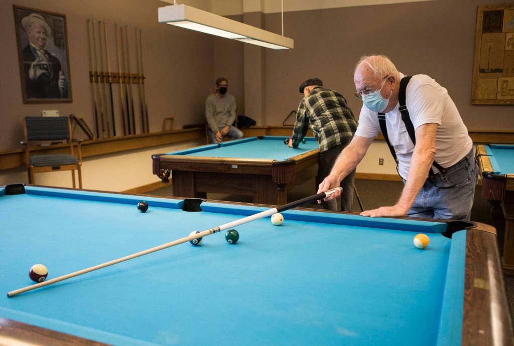 Ray King lines up his pool shot at the Carl Gipson Center on Wednesday. (Olivia Vanni / The Herald)