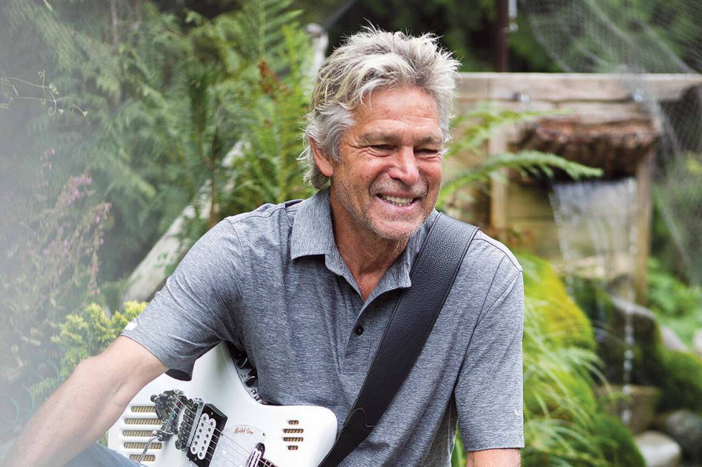Roger Fisher pauses while jamming in the garden at his Monroe home on July 8, 2021. (Olivia Vanni / The Herald)