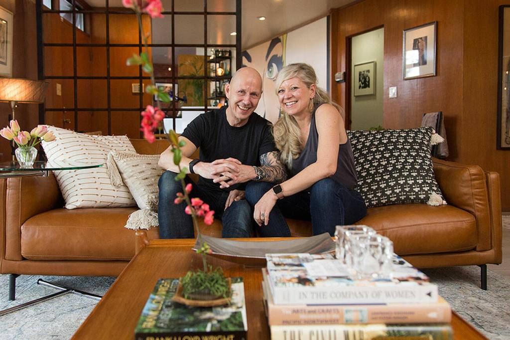 Owners Wendy and Matt Poischbeg sit in the living room of their Mid-Century Modern home on April 12, 2021 in Everett. (Andy Bronson / The Herald)