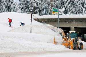 A Washington Department of Transportation snowblower clears the road under I-90 at Summit West as backcountry skiers head up the Pacific Crest Trail after a heavy snowfall at Snoqualmie Pass. Authorities say Snoqualmie Pass has received the highest snowfall in 20 years as of Jan. 3. The Washington State Department of Transportation says by Monday afternoon, 236 inches of snowfall was recorded, more than the 229 inches by Jan. 3 that was recorded in 2007 and 212 inches in 2004. (Jennifer Buchanan/The Seattle Times via AP)
