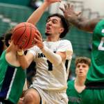 Jackson's Drilon Veliu splits the defense of Woodinville's Ryan Roth, left, and Akhil Damidi at Jackson High School Wednesday evening in Mill Creek, Washington on January 5, 2022. The Timberwolves won 76-57. (Kevin Clark / The Herald)