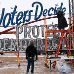 A year after the attack on the U.S. Capitol, the final touches are put on a sign saying, "Voters Decide Protect Democracy," Thursday, Jan. 6, 2022, ahead of an event on the National Mall in Washington. Thursday marks the first anniversary of the Capitol insurrection, a violent attack that has fundamentally changed Congress and prompted widespread concerns about the future of American democracy. (AP Photo/Jacquelyn Martin)