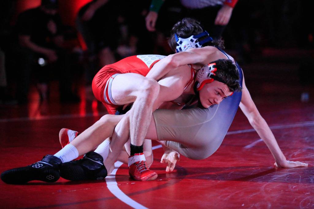 Stanwoods Bryan Roodzant wrestles Arlingtons Ethan Barnett in the 120-pound weight class at Stanwood High School on Thursday evening. (Kevin Clark / The Herald)