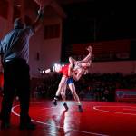 Stanwoods Mason Ferguson is lifted off the mat by Arlingtons Trevor Latta in the 182-pound weight class at Stanwood High School on Thursday evening. (Kevin Clark / The Herald)