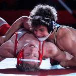 Arlingtons Dustin Baxter works to pin Stanwoods Cameron ONeill in the 145-pound weight class at Stanwood High School on Thursday evening. (Kevin Clark / The Herald)