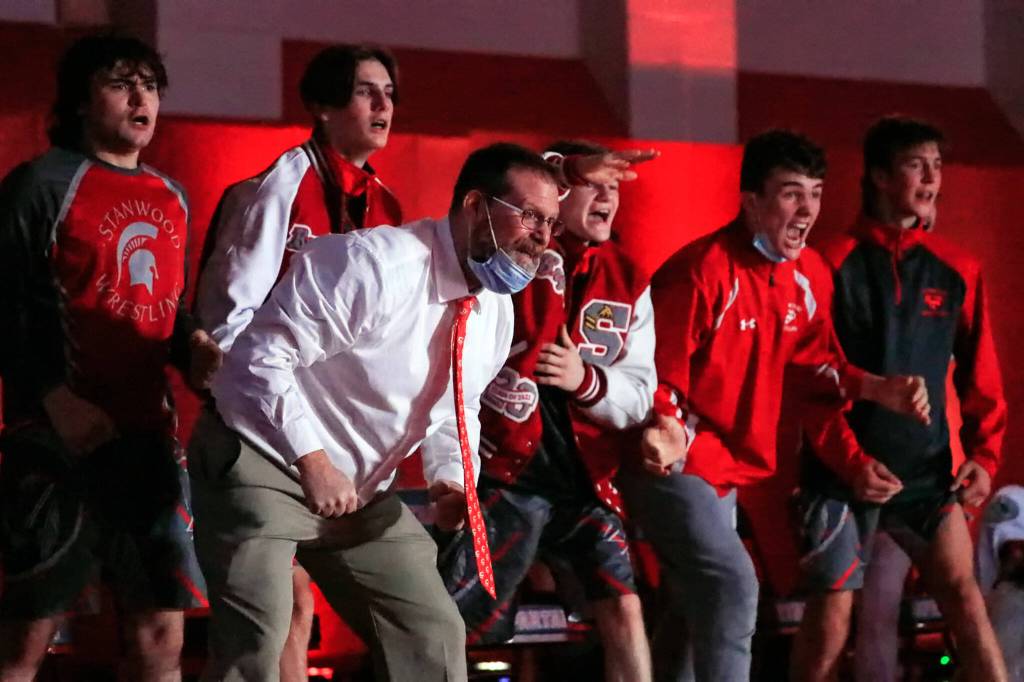Stanwoods head coach Ray Mather cheers with his team against Arlington at Stanwood High School on Thursday evening. (Kevin Clark / The Herald)