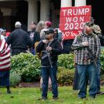 After breaching the gates around the Governors Mansion in Olympia, two men stand armed with guns in front of the residence, on Jan. 6, 2021, during a protest supporting President Donald Trump and against the counting of electoral votes in Washington, D.C., affirming President-elect Joe Bidens victory. (Ted S. Warren /Associated Press file photo)