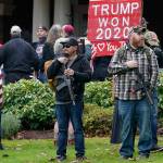 FILE - In this Jan. 6, 2021, file photo at the Capitol in Olympia, Wash., two men stand armed with guns in front of the Governor's Mansion during a protest supporting President Donald Trump and against the counting of electoral votes in Washington, DC, affirming President-elect Joe Biden's victory. The open carry of guns and other weapons would be banned on the Capitol campus and at or near any permitted public demonstration across Washington under a measure being considered by Washington lawmakers. (AP Photo/Ted S. Warren, File)
