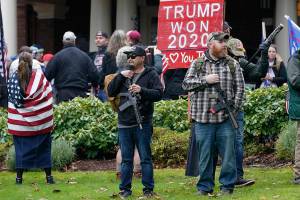 FILE - In this Jan. 6, 2021, file photo at the Capitol in Olympia, Wash., two men stand armed with guns in front of the Governor's Mansion during a protest supporting President Donald Trump and against the counting of electoral votes in Washington, DC, affirming President-elect Joe Biden's victory. The open carry of guns and other weapons would be banned on the Capitol campus and at or near any permitted public demonstration across Washington under a measure being considered by Washington lawmakers. (AP Photo/Ted S. Warren, File)