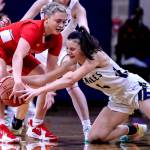 Arlingtons Maddy Fischer (right) fights for the ball with Stanwoods Grace Walker during their teams rivalry clash Saturday night. The Eagles won 57-47. (Kevin Clark / The Herald)