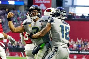 Seattle Seahawks quarterback Russell Wilson, left, celebrates his touchdown run against the Arizona Cardinals with Seattle Seahawks wide receiver Freddie Swain (18) during the second half of an NFL football game Sunday, Jan. 9, 2022, in Glendale, Ariz. (AP Photo/Darryl Webb)