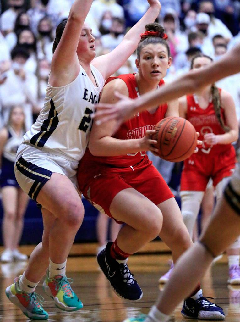 Stanwoods Vivienne Berrett works to lane with Arlingtons Katie Snow defending at Arlington High School Saturday evening in Arlington, Washington on January 8, 2022. The Eagles won 57-47. (Kevin Clark / The Herald)