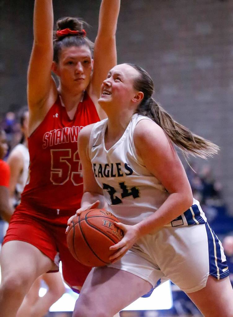 Arlingtons Katie Snow attempts a shot with Stanwoods Vivienne Berrett defending at Arlington High School Saturday evening in Arlington, Washington on January 8, 2022. The Eagles won 57-47. (Kevin Clark / The Herald)