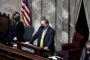 Washington Lt. Gov. Denny Heck is seen standing at the Senate podium on Monday, Jan. 10, 2022 in Olympia, Wash. Lawmakers are beginning a 60-day legislative session with a limited number of lawmakers in each chamber due to the ongoing COVID-19 pandemic (AP Photo/Rachel La Corte)