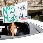 FILE - Elementary school teacher Carrie Landheer protests for stronger COVID-19 safety protocols outside Oakland Unified School District headquarters on Jan. 7, 2022, in Oakland, Calif. Officials across the U.S. are again weighing how and whether to impose mask mandates as COVID-19 infections soar and the American public grows weary of pandemic-related restrictions. Much of the debate centers around the nation’s schools, some of which closed due to infection-related staffing issues. (AP Photo/Noah Berger, File)