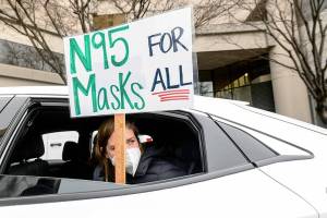 FILE - Elementary school teacher Carrie Landheer protests for stronger COVID-19 safety protocols outside Oakland Unified School District headquarters on Jan. 7, 2022, in Oakland, Calif. Officials across the U.S. are again weighing how and whether to impose mask mandates as COVID-19 infections soar and the American public grows weary of pandemic-related restrictions. Much of the debate centers around the nation’s schools, some of which closed due to infection-related staffing issues. (AP Photo/Noah Berger, File)