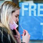 Sam Dawson administers a collection swab herself Thursday afternoon at the walk-up COVID testing center on Wetmore Ave in Everett, Washington on January 13, 2022. (Kevin Clark / The Herald)