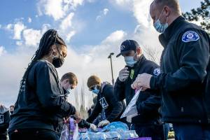 Marysville Pilchuck student Gianna Frank and Marysville firefighters bag puzzles and snacks in Marysville, Washington on January 17, 2022. (Isabella Breda / The Herald)