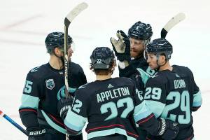 Seattle Kraken defenseman Vince Dunn (29) is greeted by teammates after he scored a goal against the Chicago Blackhawks during the second period of an NHL hockey game, Monday, Jan. 17, 2022, in Seattle. (AP Photo/Ted S. Warren)