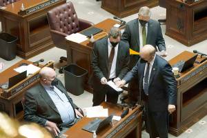 State Sens, Ron Muzzall, R-Whidbey Island, left, Simon Sefzik, R-Ferndale, center left, Keith Wagoner, R-Sedro-Woolley, center right, and Chris Gildon, R-Puyallup, right, confer on the floor of the Senate during a recess, Wednesday, Jan. 19, 2022, at the Capitol in Olympia, Wash. (AP Photo/Ted S. Warren)