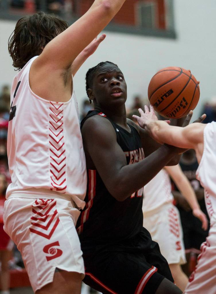 Mountlake Terraces Zaveon Jones tries to get around Stanwoods Kolten Bartram-Scott for a layup during Thursdays game in Stanwood. (Olivia Vanni / The Herald)