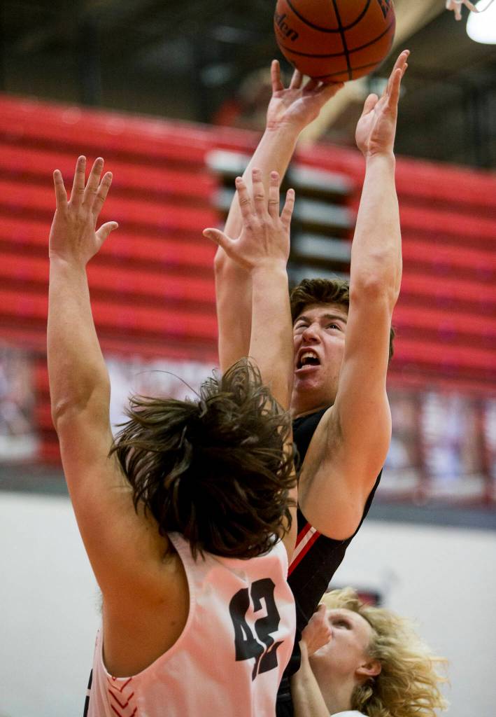 Mountlake Terraces Adison Mattix attempts a layup over Stanwoods Kolten Bartram-Scott during Thursdays game in Stanwood. (Olivia Vanni / The Herald)