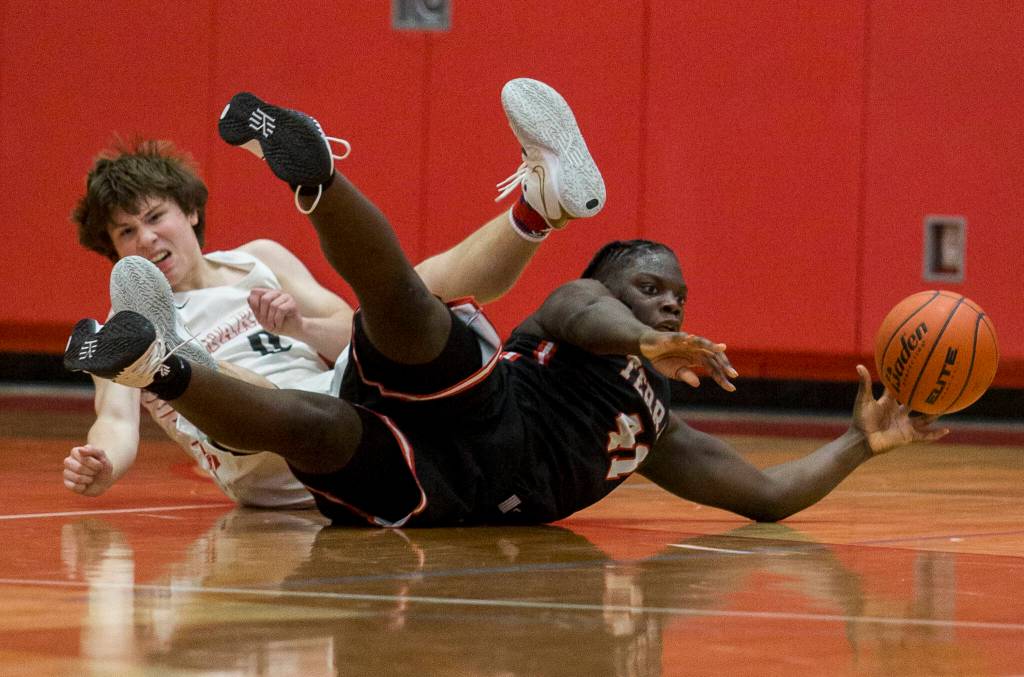 Mountlake Terraces Zaveon Jones and Stanwoods Owen Thayer fall to the ground while going after the ball during Thursdays game in Stanwood. (Olivia Vanni / The Herald)