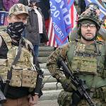 FILE - In this Jan. 6, 2021, file photo at the Capitol in Olympia, Wash., two men stand armed with guns at a protest supporting President Donald Trump and against the counting of electoral votes in Washington, DC, affirming President-elect Joe Biden's victory. The open carry of guns and other weapons would be banned on the Capitol campus and at or near any permitted public demonstration across Washington under a measure being considered by Washington lawmakers. (AP Photo/Ted S. Warren, File)