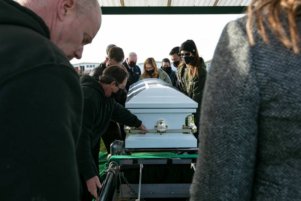 Pallbearers guide the caskets of Adriana and Mariel Gil to their resting spot during the girls funeral Friday, Jan. 28, 2022, at Cypress Lawn Memorial Park in Everett. (Ryan Berry / The Herald)