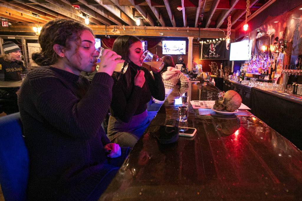 Taryn Salter and Rachel Ford take shots at the bar Thursday at Vessel Taphouse in Lynnwood. (Ryan Berry / The Herald)