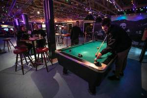 Rachel Ford and Taryn Salter watch as Erik Ford and Kam Durden play pool Thursday, Jan. 27, 2022, at Vessel Taphouse in Mill Creek, Washington. (Ryan Berry / The Herald)