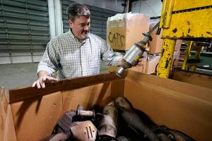 Troy Webber, owner of Chesterfield Auto Parts, holds a used catalytic converter that was removed from one of the cars at his salvage yard Friday Dec. 17, 2021, in Richmond, Va. Thefts of the emission control devices have jumped over the last two years as prices for the precious metals they contain have skyrocketed. (AP Photo/Steve Helber)