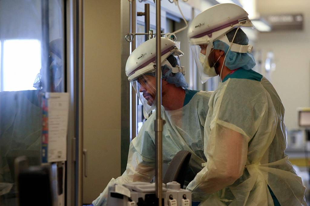 Aaron Fox, left, and Jon Wilbourne enter a patients room May, 19, 2020, at Providence Regional Medical Center Everett. (Andy Bronson/ Herald file)