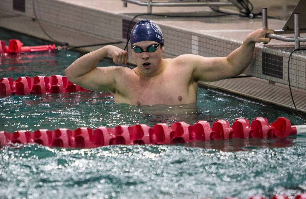 Glacier Peaks Keegan Lisenby flexes his arms after winning the 100-yard breaststroke during a swim meet against Lake Stevens and Snohomish on Thursday in Snohomish. (Olivia Vanni / The Herald)