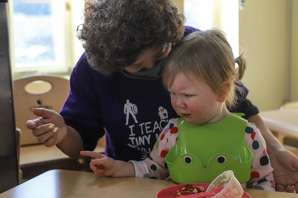 Hannah Roberts (left) helps Miriam, 2, with snack time at the Edmonds Lutheran Learning Center. (Kevin Clark / The Herald)