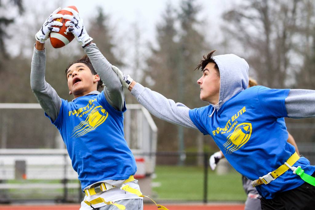 Julian Wilson, 14, stretches for a reception with Jacob Hiatt II, 15 defending during practice Jan. 16 at Harbour Pointe Middle School in Mukilteo. (Kevin Clark / The Herald)