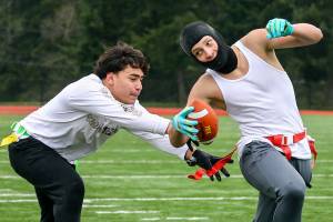 Tristan Lolohea, 15, reaches out to grab the flag of Keagan Howard, 14, during practice Sunday morning at Harbour Pointe Middle School in Mukilteo, Washington on January 16, 2022. (Kevin Clark / The Herald)
